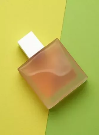 Productos de perfumería, frasco de colonia con fondo verde y amarillo | Droperba